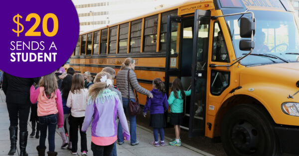 Students at a yellow bus attending an arts field trip