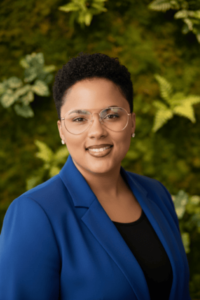 Professional portrait of a woman in a blue blazer smiling outdoors, representing ArtsWave's community engagement and arts support initiatives.