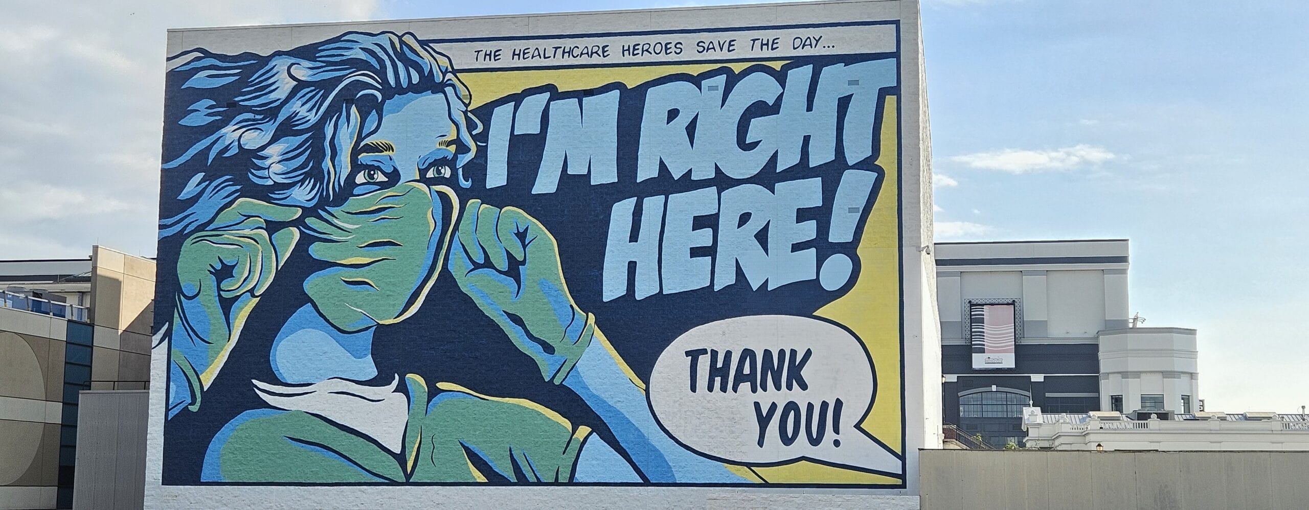 1. A mural honoring healthcare workers shows a woman wearing a mask and gloves, with bold text thanking healthcare heroes, emphasizing gratitude for essential workers during the pandemic.